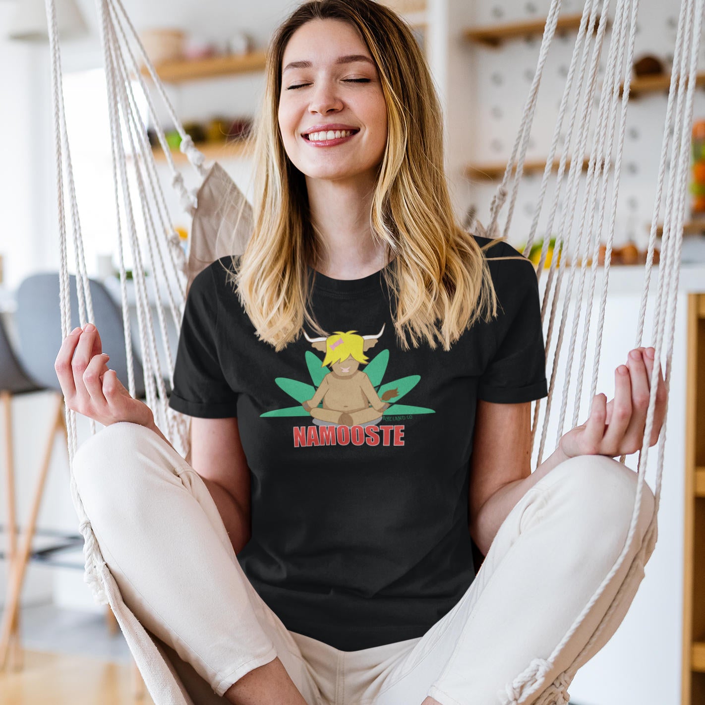 woman doing yoga and wearing a black namooste highland cow t-shirt