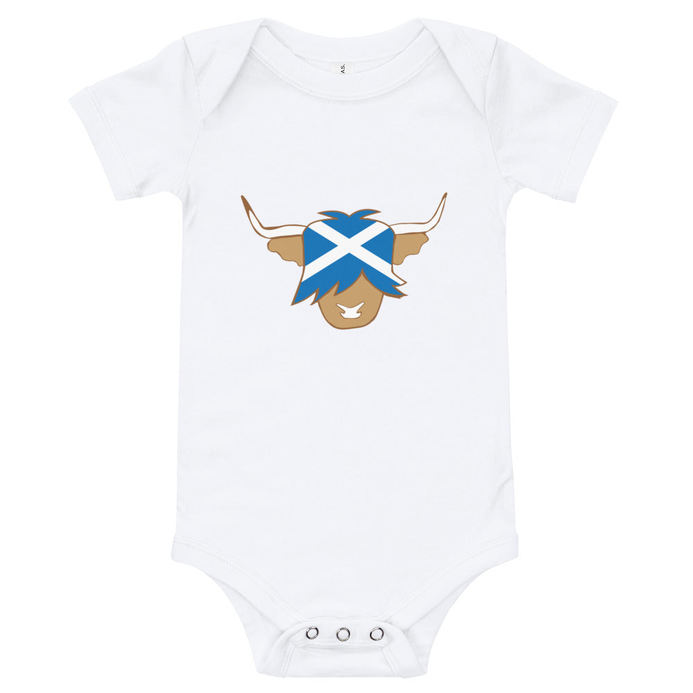 White babygrow featuring a super cute Scottish highland cow with the flag of Scotland.
