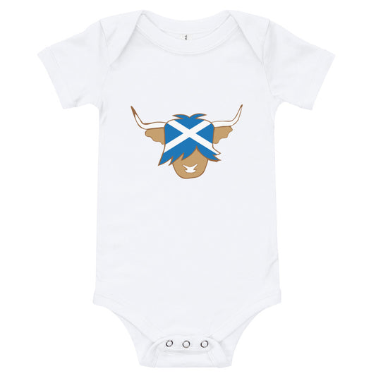 White babygrow featuring a super cute Scottish highland cow with the flag of Scotland.