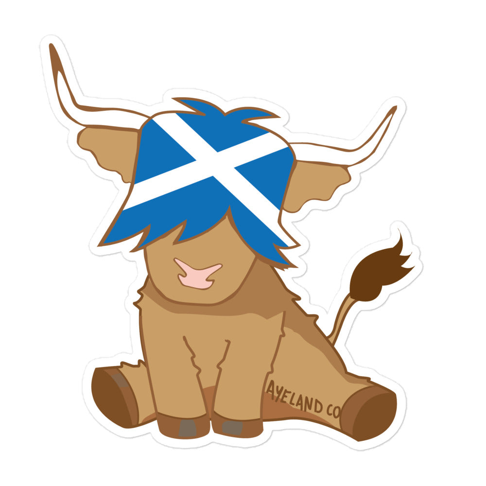 Sticker of a highland cow cartoon with the flag of scotland on it