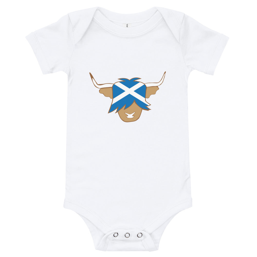 White babygrow featuring a super cute Scottish highland cow with the flag of Scotland.