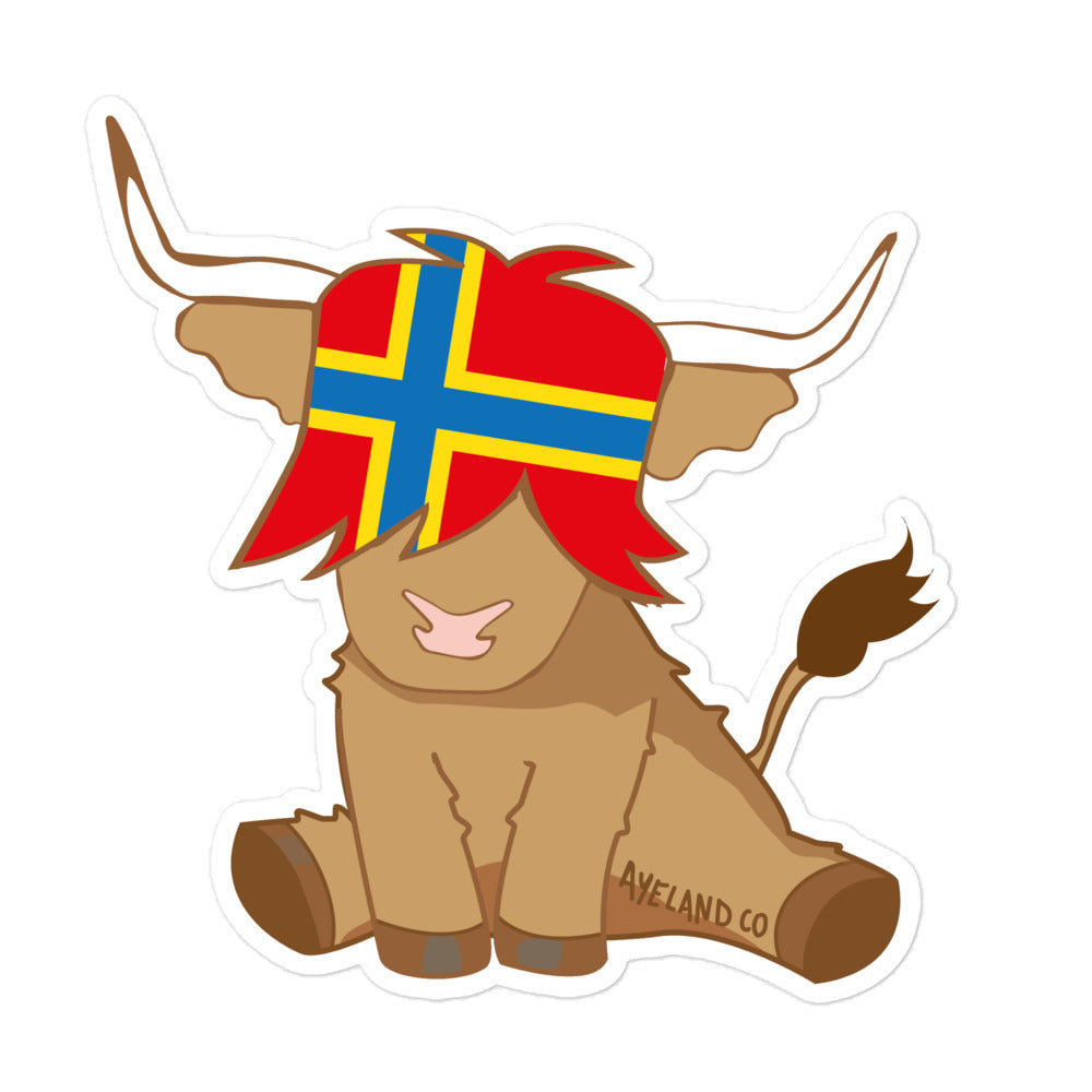 sticker of a highland cow with the flag of shetland island