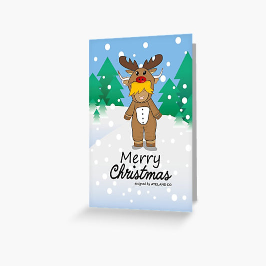 christmas card of a highland cow wearing a rudolph onesie at the mountain