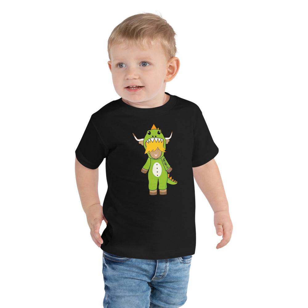 Boy wearing a black highland cow t-shirt featuring a cute highland cow wearing a T-rex onesie