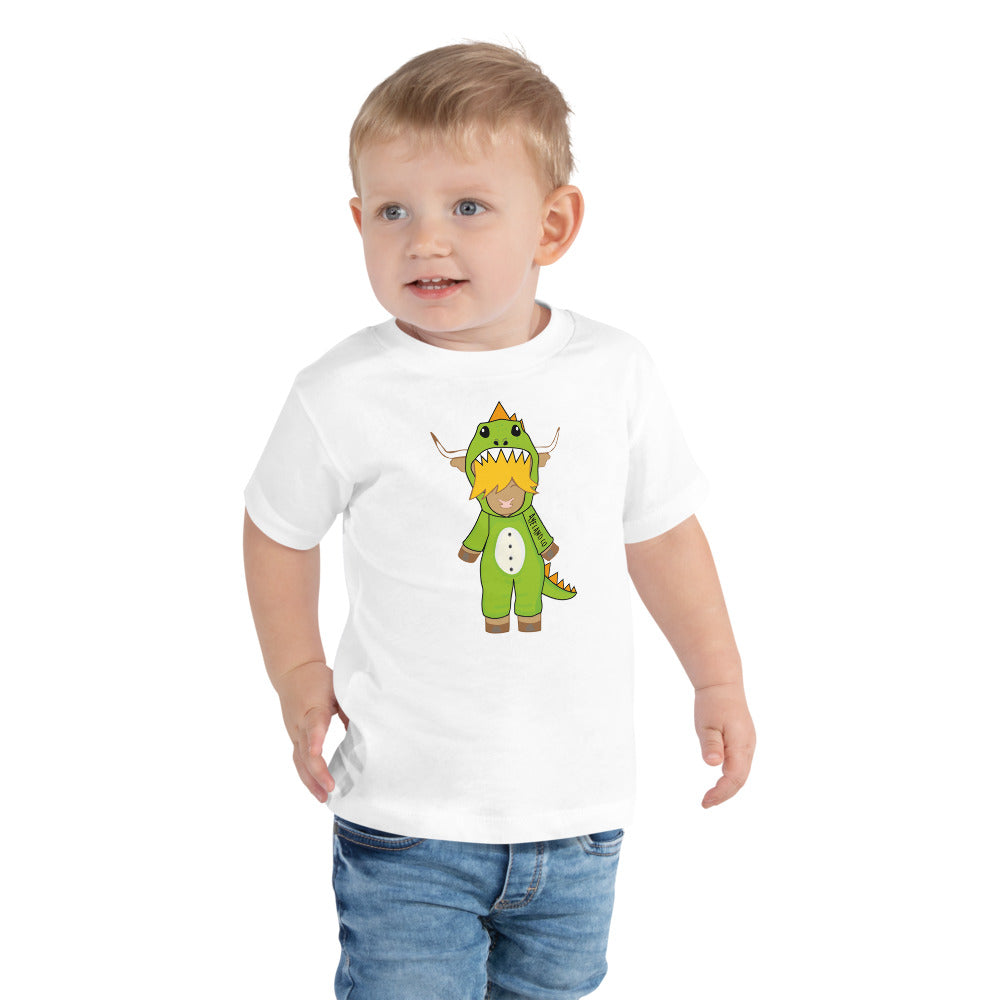 Boy wearing a white highland cow t-shirt featuring a cute highland cow wearing a T-rex onesie